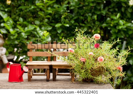Wooden chairs and red watering can. Small flower garden, Concept The Garden of Love