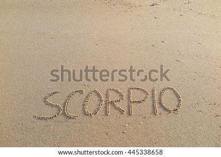 written words "SCORPIO" on sand of beach