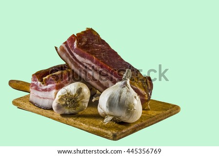 Domestic bacon and garlic on wooden kitchen board.