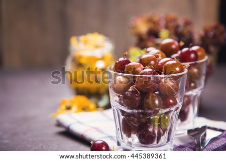 many wet raw ripe gooseberry in glass with dry calendula