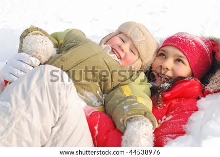 Children rejoice to the come winter and cheerfully play white fluffy snow