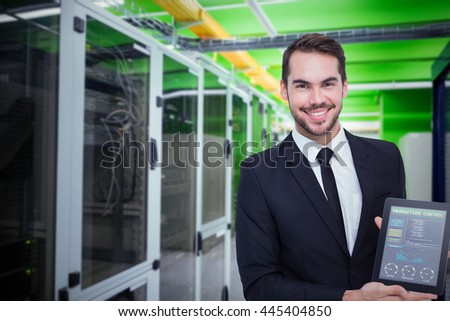 Smiling businessman showing his tablet pc against view of data technology