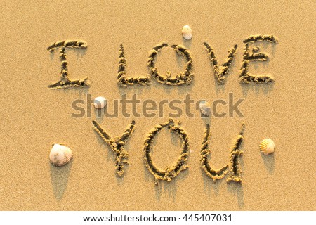 I Love You - drawn by hand on a sandy golden sea beach.