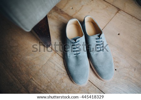Wedding. Blue suede shoes standing on the wooden floor next to the chair