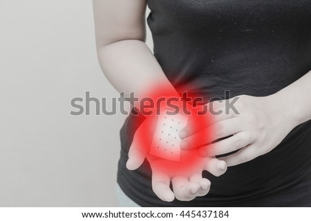 Women Hand - Wrist Pain and sticking plaster.Concept photo with Color Enhanced pale skin with read spot indicating location of the pain.