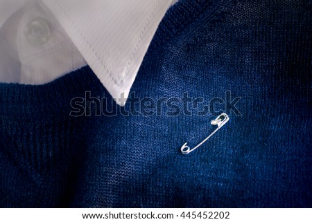 Safety pin clasp on clothing or shirt. For safety pin campaign that encouraging the British public and show solidarity after Brexit (UK or EU referendum result). Safety pin symbolic or Safety pin sign Royalty-Free Stock Photo #445452202