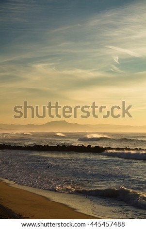 portrait view of atlantic ocean with mountain la rhune in the back in sunset, capbreton, france