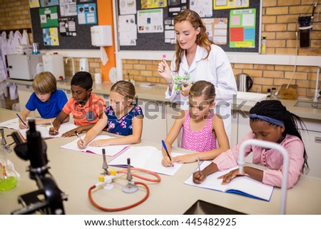 Teacher giving lesson to her students at school