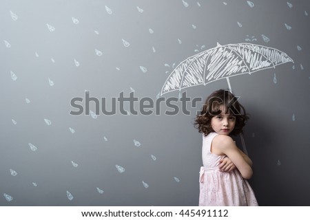Upset young lady under the rain depicted with chalk in the background. Heavy water drops and lovely umbrella on the wall.