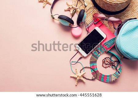  Top view of essential modern young lady or girl on vacations.Woman's summer holidays accessories composed on pastel color background. Beach fashion , summer concept. Trendy colors. Royalty-Free Stock Photo #445551628