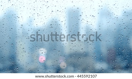 close up macro image of rain drops pouring down on glass window on a raining day. dar sad depressed mood background. climate weather change concept 