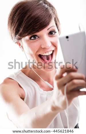 Laughing attractive woman posing for a selfie on her mobile phone with her mouth open and a happy expression