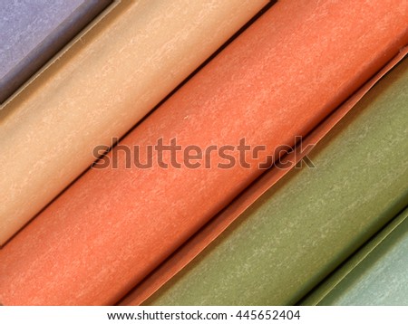 Close-up of beautiful shades of color textured flimsy paper rolls, diagonal composition 
