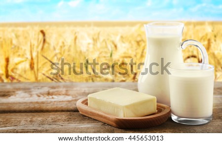 Conception of dairy food on table on countryside background