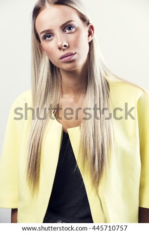 Fashion portrait of a blonde woman in yellow jacket
