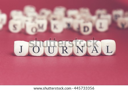 Journal word written on wood cube with red background