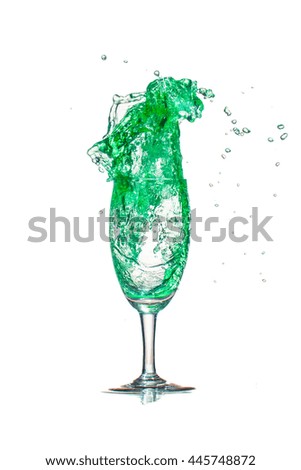 green cocktail splash out of glass on white background.
