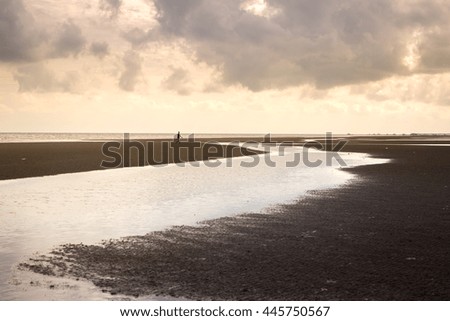 golden evening light at tropical beach with channel of water lead to the sea