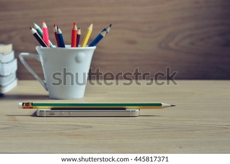 Selective focus Smartphone and pencil on desk wood background 