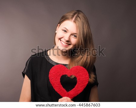 Young happy woman with shape of red heart, health care or love concept image