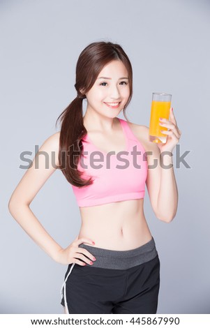 woman drinks orange juice isolated on gray background