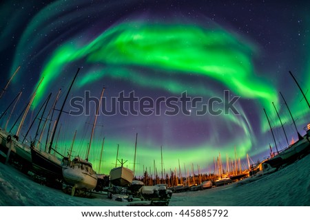 Wonderful aurora borealis flying over yacht port at Great Slave Lake   Royalty-Free Stock Photo #445885792
