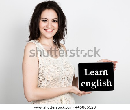 technology, internet and networking - close-up successful woman holding a tablet pc with learn english sign. internet technology in tourism