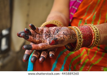 Close up photo of Indian woman's palms with henna tattoo and red bangles
 Royalty-Free Stock Photo #445889260