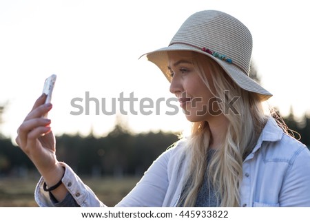 closeup woman using phone during sunset