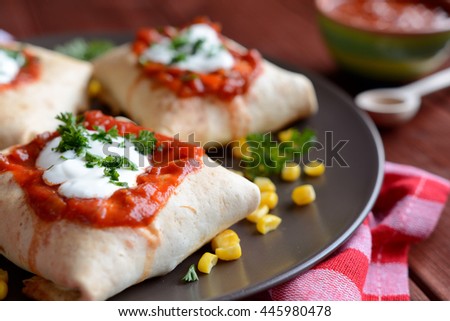 Burritos with taco sauce and sour cream