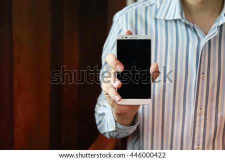 man show his smart phone, smart phone in the hand , young adult using mobile smart phone, Internet of things lifestyle with wireless communication and internet with smartphone.
