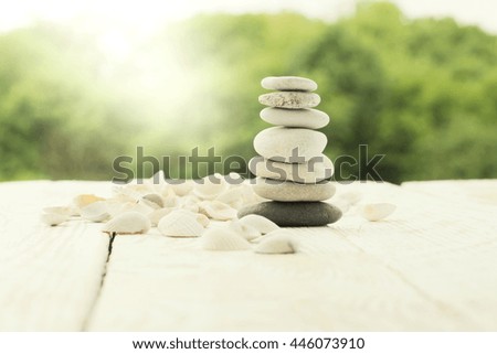 Stones pyramid and shells on the wooden background. Toned photo