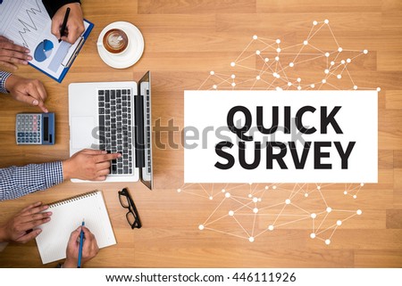 QUICK SURVEY              Business team hands at work with financial reports and a laptop