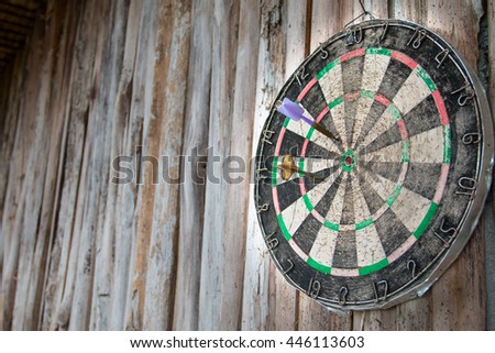 Old dart board on wooden background in concept long time to target or success