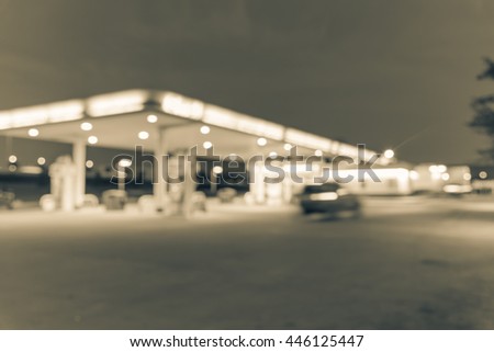 Blurred of gas station at blue hour. Defocused, out of focus gas station and convenience store in evening twilight. Abstract blur petrol station background with copy space. Vintage filter look.
