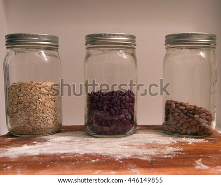 Three glass jars filled with oats and beans.