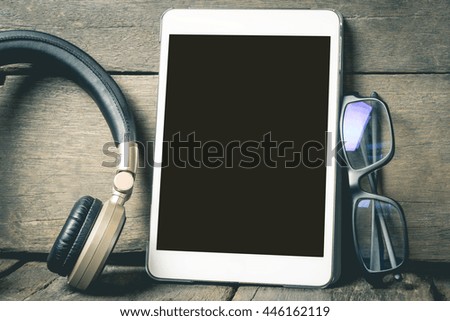 Blank tablet screen with headphone and glasses for entertainment.