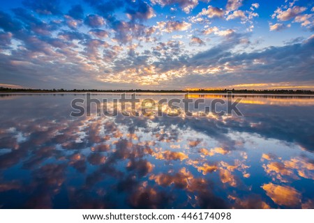 A colorful pattern of cloudy on sky is reflecting on water as sunrise timing located north east of Thailand