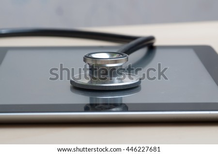 healthcare and technology concept - tablet  and stethoscope 