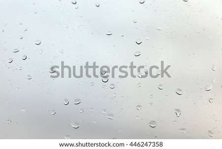   photographed close-up drops of rain left on the glass, raindrops on the window, the autumn and multicolored background, out of focus, defocus