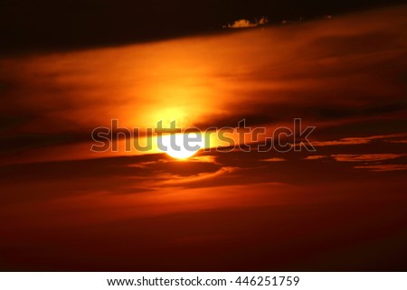 Setting summer sun against an orange sky