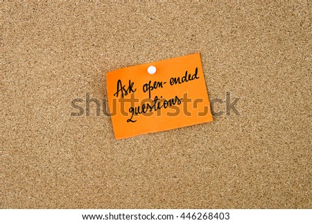 Ask Open-Ended Questions written on orange paper note note pinned on cork board with white thumbtack, copy space available