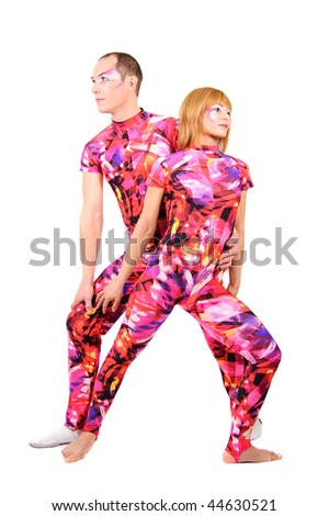 A pair of gymnasts in colorful stage costumes perform tricks on a white background