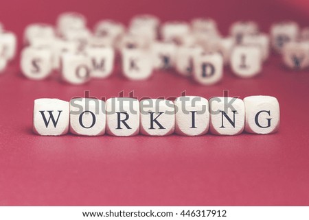 Working word written on wood cube with red background