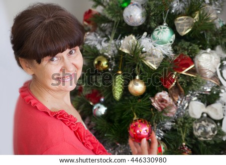 Mature age good looking woman against of Christmas tree. Christmas background