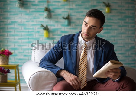 Young man in a suit with book in his hands. Business style or student.