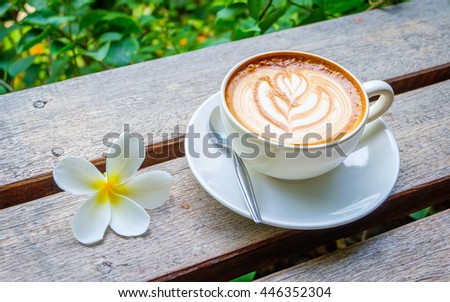 White art coffee cup and plumeria on wooden table, relaxation morning.