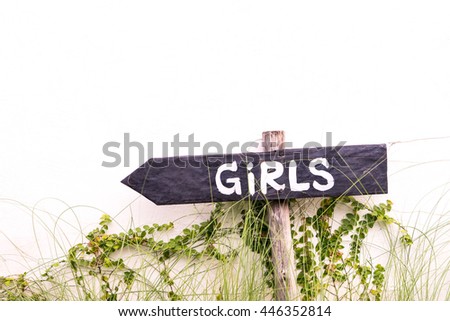 Girl text on an arrow sign pointing left for toilet bathroom.