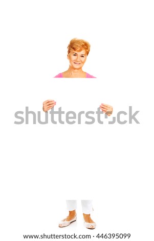Smiling senior woman holding empty banner