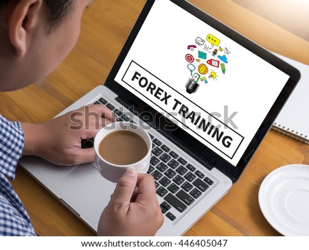 FOREX TRAINING Businessman at work. Close-up top view of man working on laptop while sitting at the wooden desk , coffee